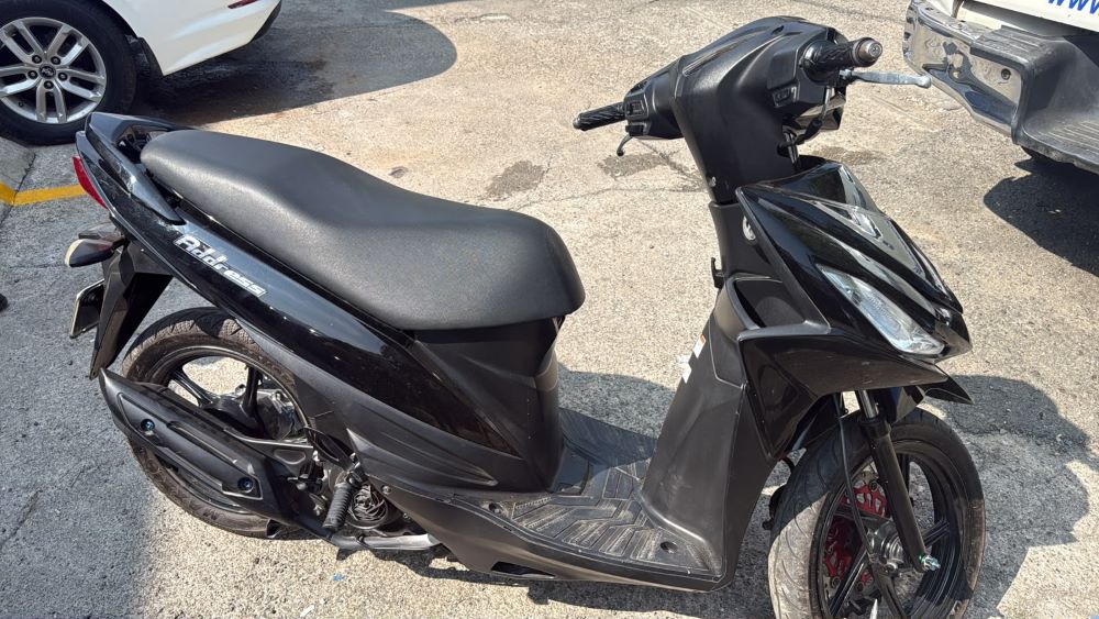 Scooter negra aparcada en el asfalto