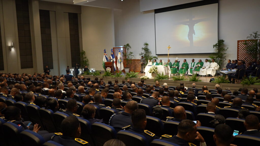 Misa en un auditorio con oficiales presentes.