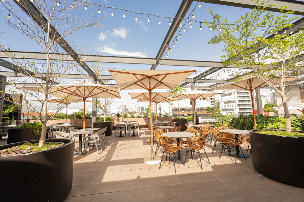 Terraza al aire libre con mesas y sombrillas.