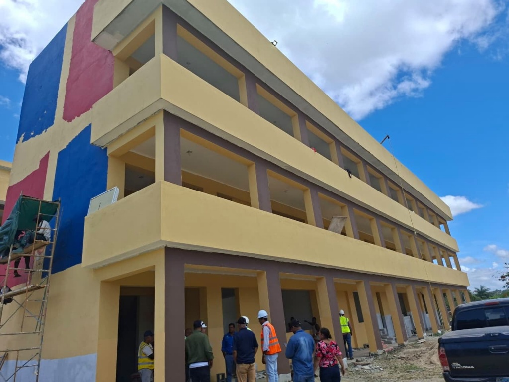 Edificio en construcción con trabajadores visibles.